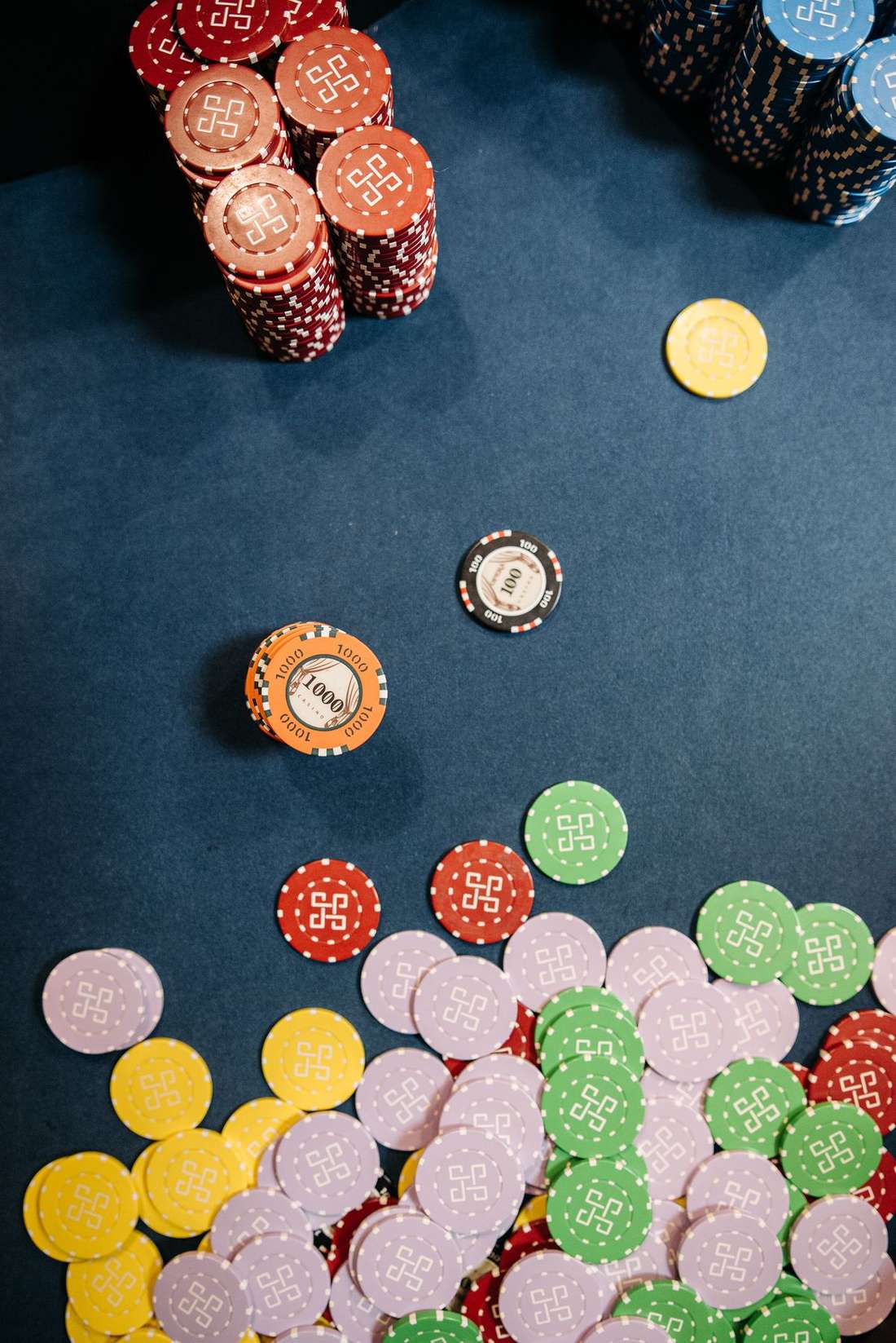 Chip poker bertumpuk di samping kartu terbuka di meja