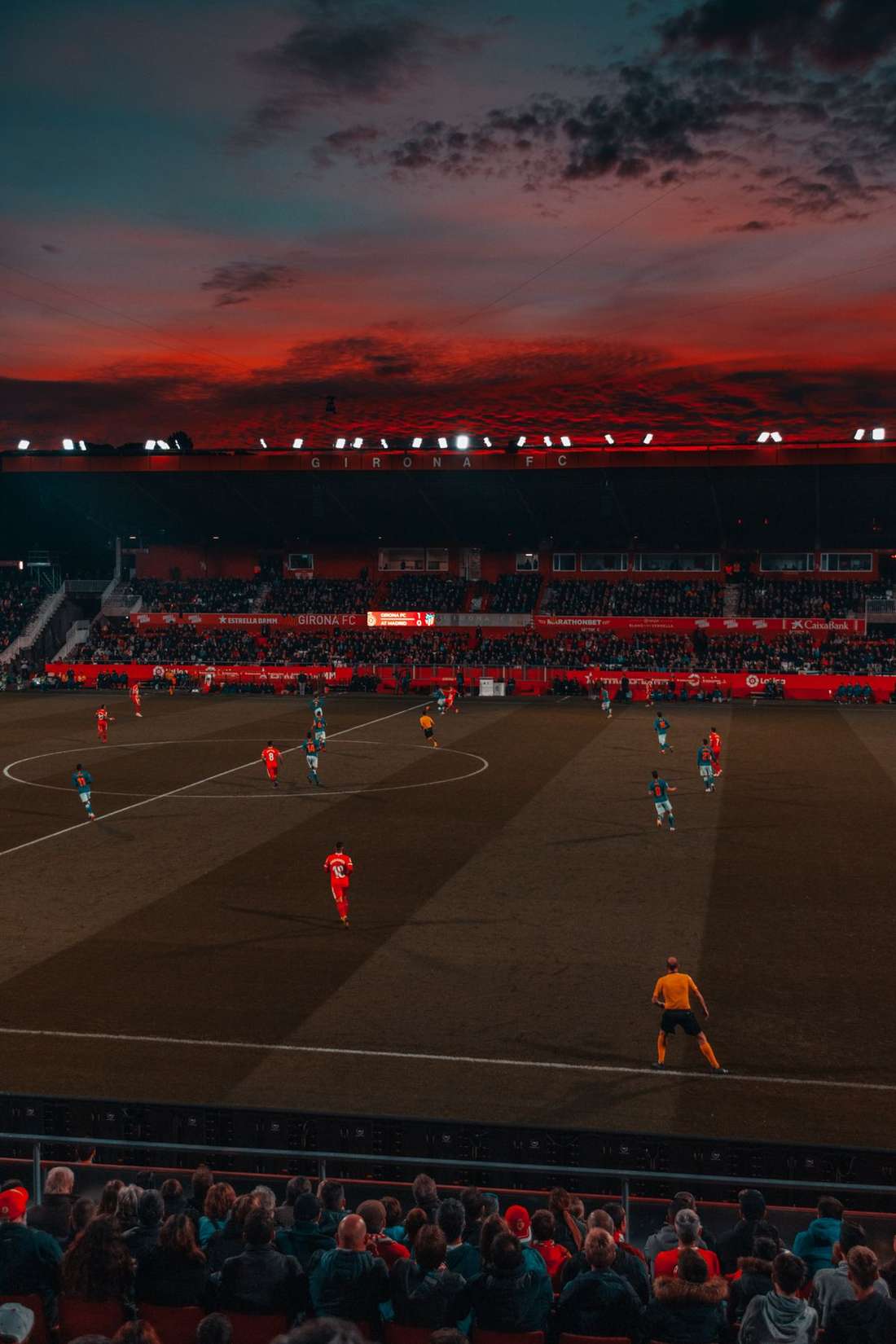 Stadion sepak bola dengan lampu sorot menyala di malam pertandingan